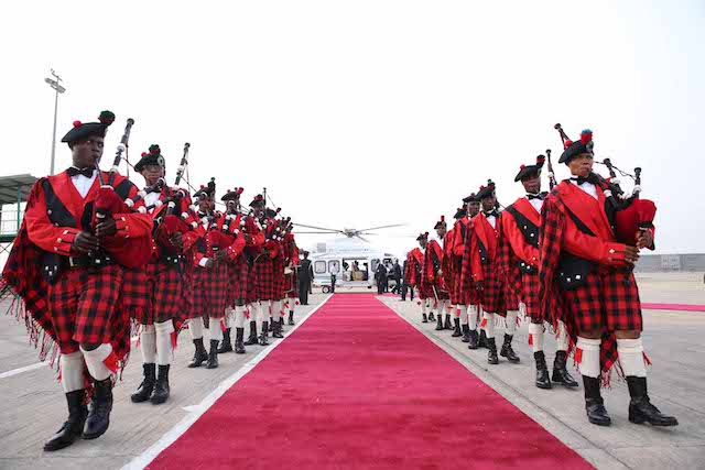 The bagpipers line the route to the Presidential chopper, in the background